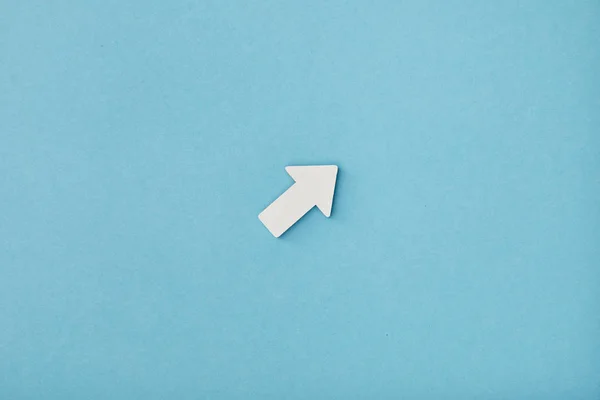 Vista superior de flecha diagonal blanca sobre fondo azul - foto de stock