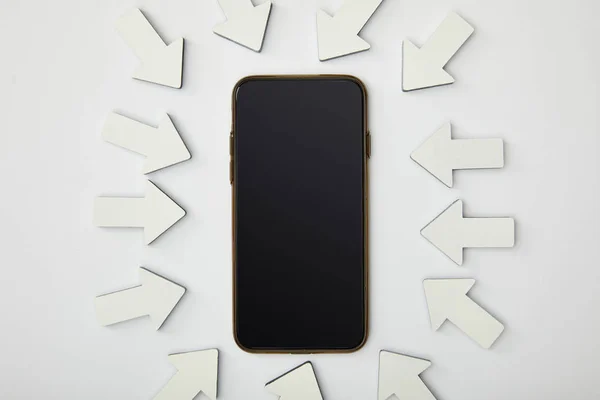 Vue du haut du smartphone en ellipse avec des pointeurs blancs sur fond gris — Photo de stock