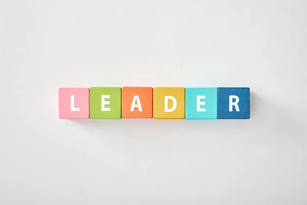 Vista superior de letras líder feitas de blocos multicoloridos em fundo cinza — Fotografia de Stock