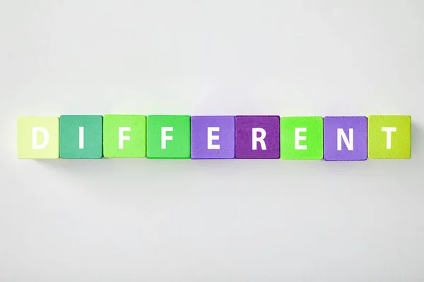 Vista superior de diferentes letras feitas de cubos multicoloridos em fundo cinza — Fotografia de Stock