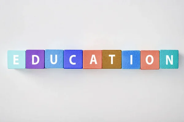 Top view of education lettering made of multicolored blocks on grey background — Stock Photo