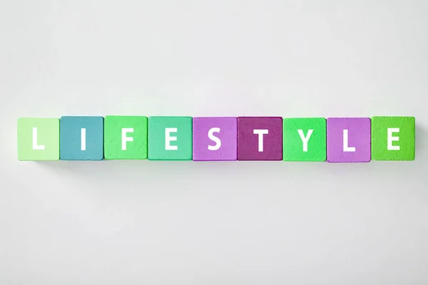 Top view of lifestyle lettering made of multicolored blocks on grey background — Stock Photo