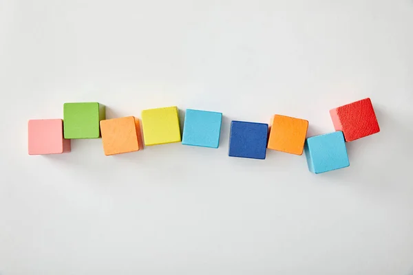Top view of multicolored cubes laid out on grey background — Stock Photo