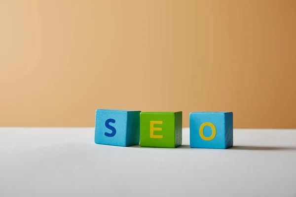 Seo lettering made with multicolored blocks on white table and beige background — Stock Photo