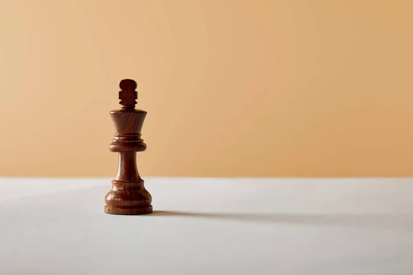 Pieza de madera rey sobre mesa blanca y fondo beige - foto de stock