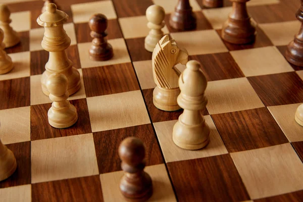 Piezas de ajedrez sobre tablero de ajedrez marrón madera - foto de stock