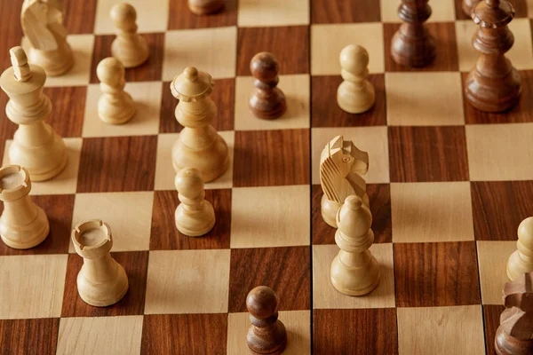 Beige and brown chess pieces on wooden chess board — Stock Photo