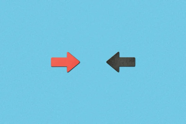 Top view of opposite horizontal red and black arrows on blue background — Stock Photo