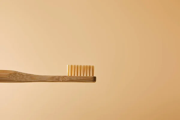 Cepillo de dientes marrón bambú sobre fondo beige - foto de stock