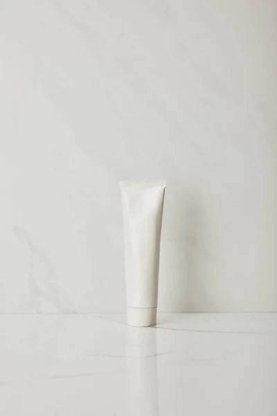 Dentifricio in tubo su fondo marmo bianco — Foto stock