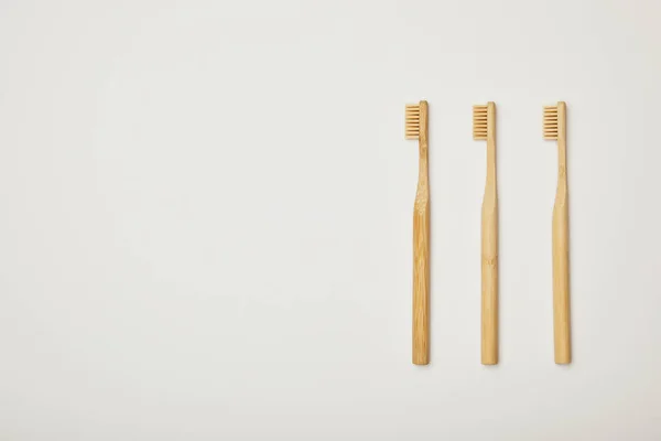 Vue de dessus des brosses à dents marron bambou sur fond blanc — Photo de stock