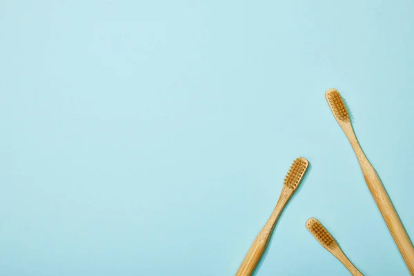 Vista superior de cepillos de dientes de bambú sobre fondo azul — Stock Photo
