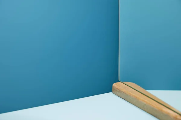 Mesa blanca y espejo sobre fondo azul - foto de stock