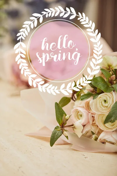 Bouquet of beige roses on wooden table with hello spring illustration in circle — Stock Photo