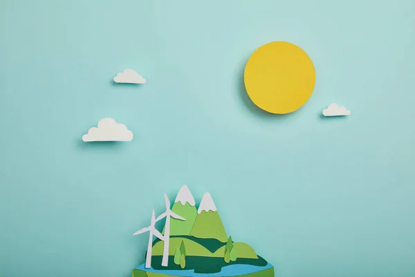 Top view of paper cut planet with renewable energy sources on turquoise background, earth day concept — Stock Photo