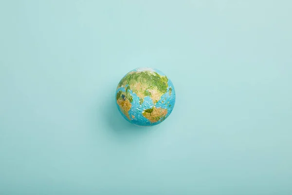 Top view of planet model on turquoise background, earth day concept — Stock Photo