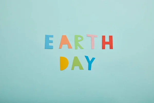 Вид цветных бумажных букв на бирюзовом фоне, концепция Дня Земли — стоковое фото