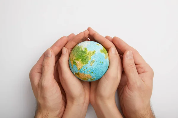 Top view of woman and man holding planet model on grey background, earth day concept — Stock Photo