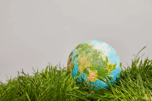 Planète modèle placé sur la surface de l'herbe verte, concept de jour de la terre — Photo de stock