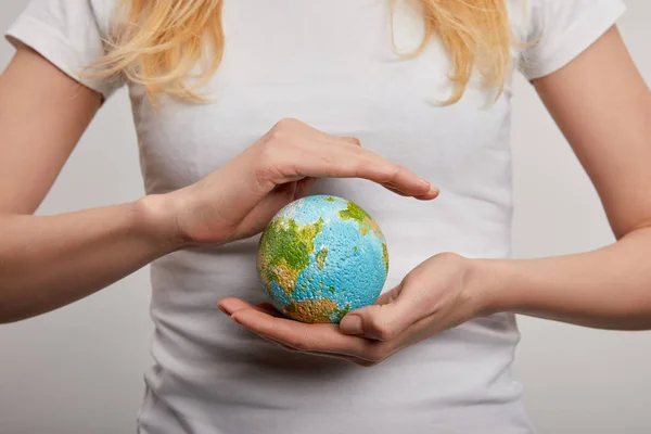 Frau mit Planetenmodell auf grauem Hintergrund, Earth Day Konzept — Stockfoto