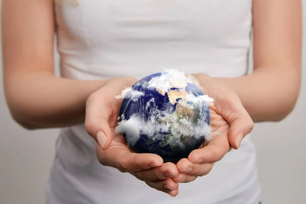 Mujer sosteniendo modelo planeta sobre fondo gris, concepto del día de la tierra - foto de stock