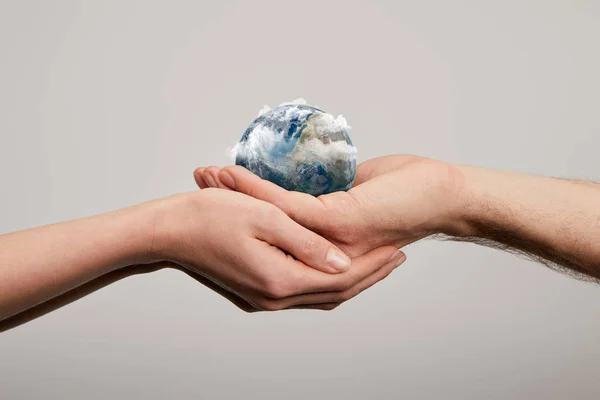 Man and woman holding planet model on grey background, earth day concept — Stock Photo