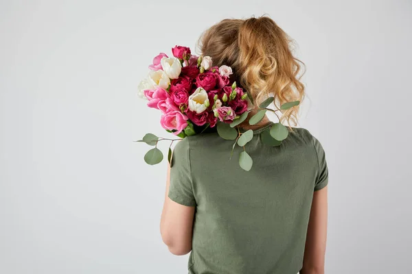 Back view of girl holding bouquet with tulips and roses isolated on grey with copy space — Stock Photo