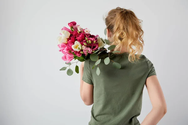 Back view of girl holding bouquet with tulips and roses isolated on grey with copy space — Stock Photo