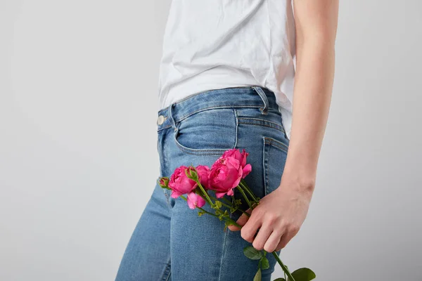 Vue recadrée de fille tenant des roses roses isolées sur gris — Photo de stock