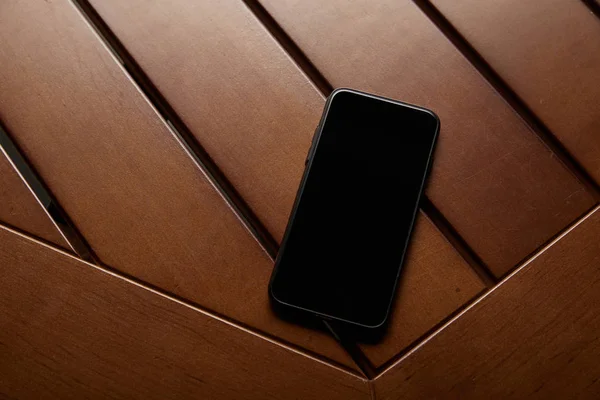 Вид зверху смартфона з порожнім екраном на дерев'яному столі — стокове фото