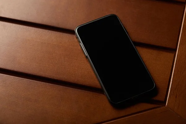 Smartphone with blank screen and copy space on wooden table — Stock Photo