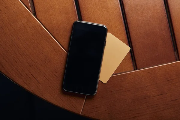 Vista superior del smartphone con pantalla en blanco y tarjeta de crédito - foto de stock