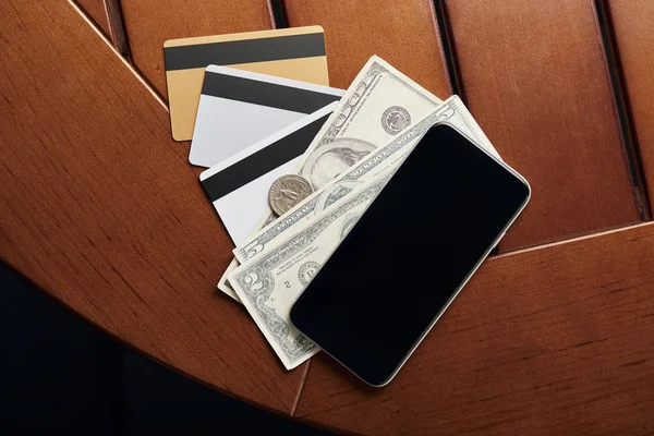 Top view of credit cards, cash and smartphone on table — Stock Photo