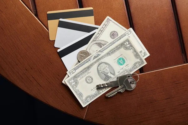 Вид зверху на кредитні картки, готівку і ключі на столі — стокове фото