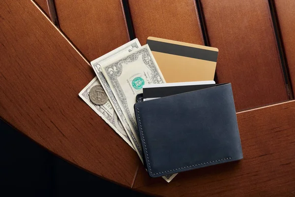 Vista superior de tarjetas de crédito, efectivo y billetera en la mesa - foto de stock