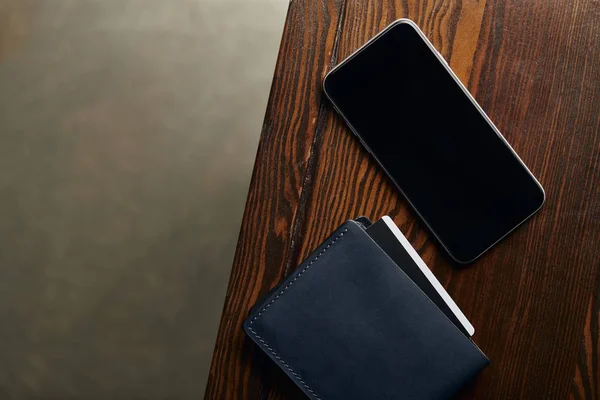 Верхний вид кошелька с кредитной картой и смартфона с пустым экраном — стоковое фото
