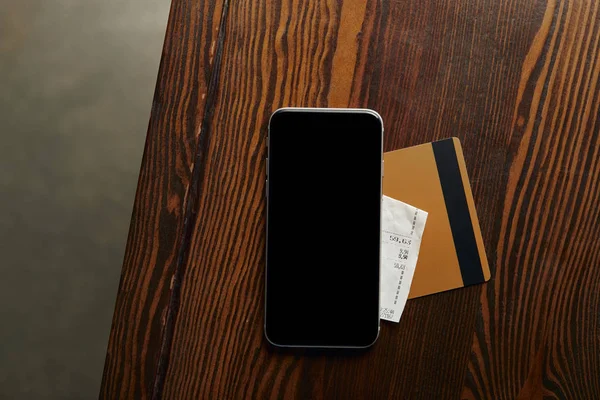 Top view of credit card, smartphone, cheque on wooden table — Stock Photo