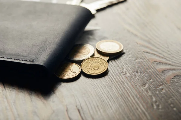 Close up of leather wallet and coins on wooden table — Stock Photo