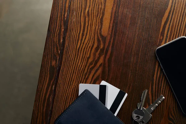 Top view of credit cards, smartphone, keys and wallet on wooden surface — Stock Photo