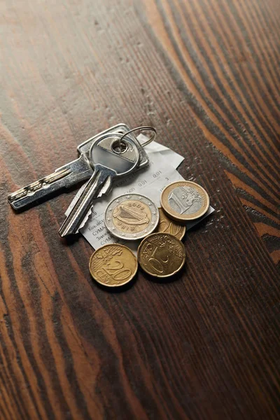 Keys, cheque and coins on wooden table with copy space — Stock Photo