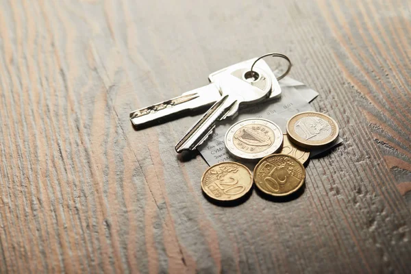 Ключи, чеки и монеты на деревянном столе с копировальным местом — стоковое фото