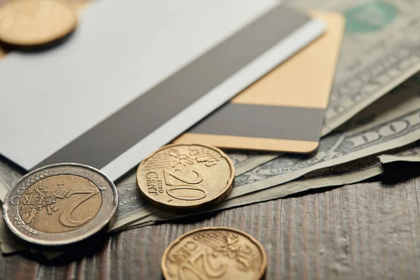 Selective focus of coins with cash and  credit cards on background — Stock Photo