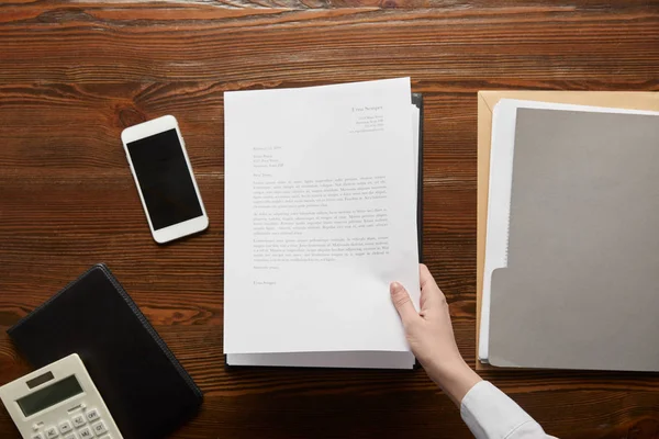 Vista parcial del documento de tenencia del empresario en el lugar de trabajo con espacio para copias - foto de stock