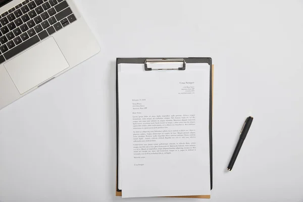 Vue du haut du document sur presse-papiers, stylo, ordinateur portable sur la table — Photo de stock