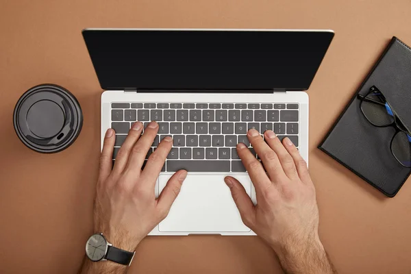 Vista ritagliata di uomo d'affari digitando sul computer portatile sul posto di lavoro — Foto stock