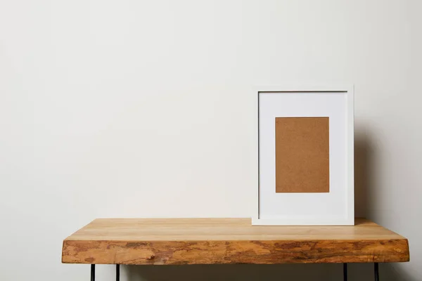 Marco en blanco sobre mesa de madera sobre fondo blanco - foto de stock