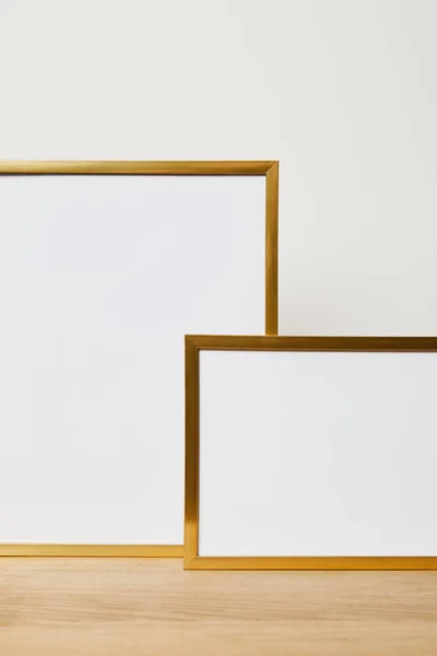 Decorative blank frames on wooden table at home — Stock Photo