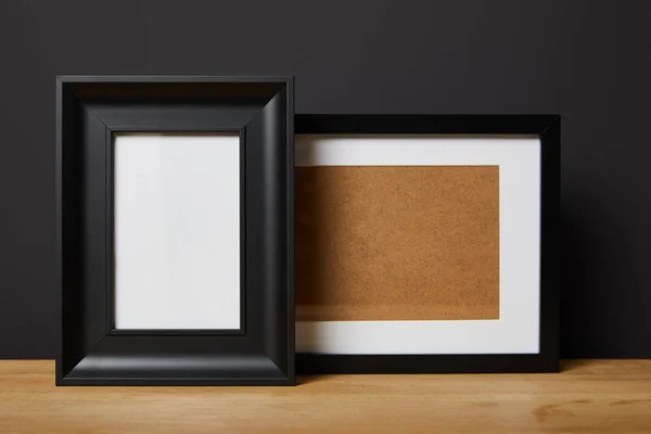 Black blank frames on wooden table at home — Stock Photo