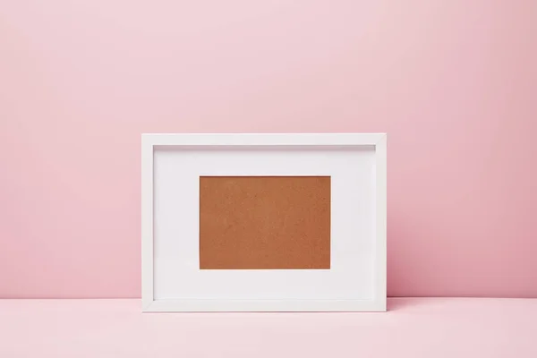 Blank decorative frame on pink surface at home — Stock Photo