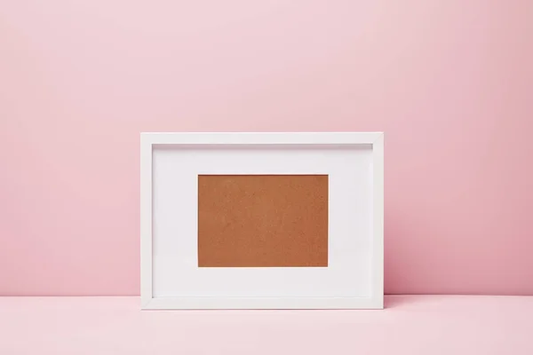 Moldura decorativa em branco na superfície rosa em casa — Fotografia de Stock